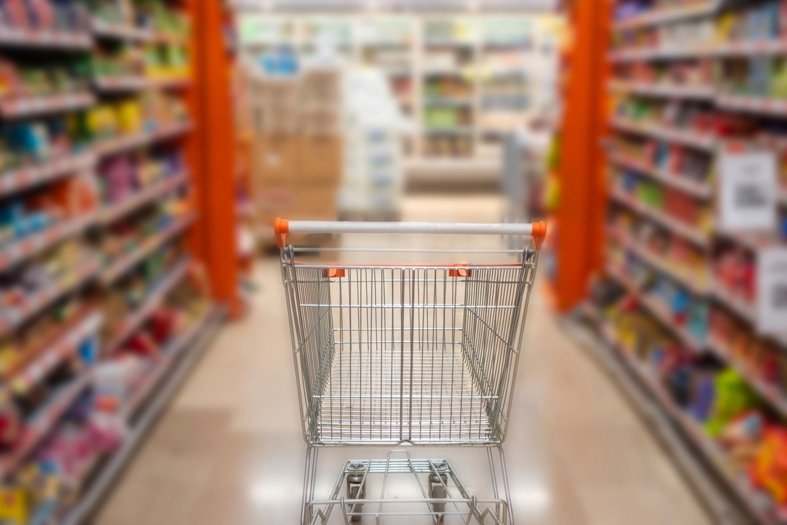 Supermarket aisle with fresh produce and grocery shelves
